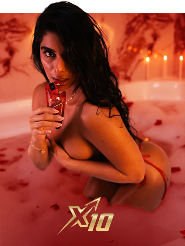 Mujer en una bañera con velas sosteniendo un sachet de X10